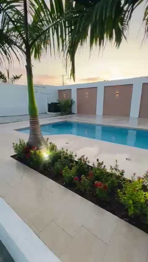 Palm-framed pool courtyard at Coastline Condos at dusk — real photo of the finished amenity