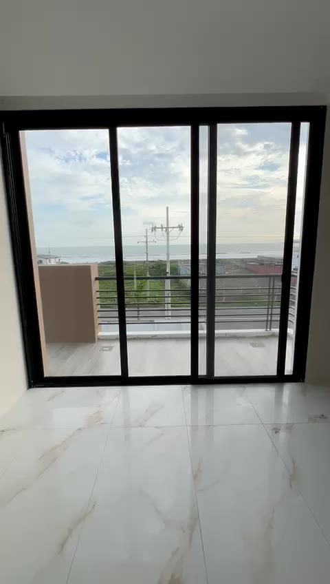 Ocean view through floor-to-ceiling sliding doors — residence in final finishes, October 2026